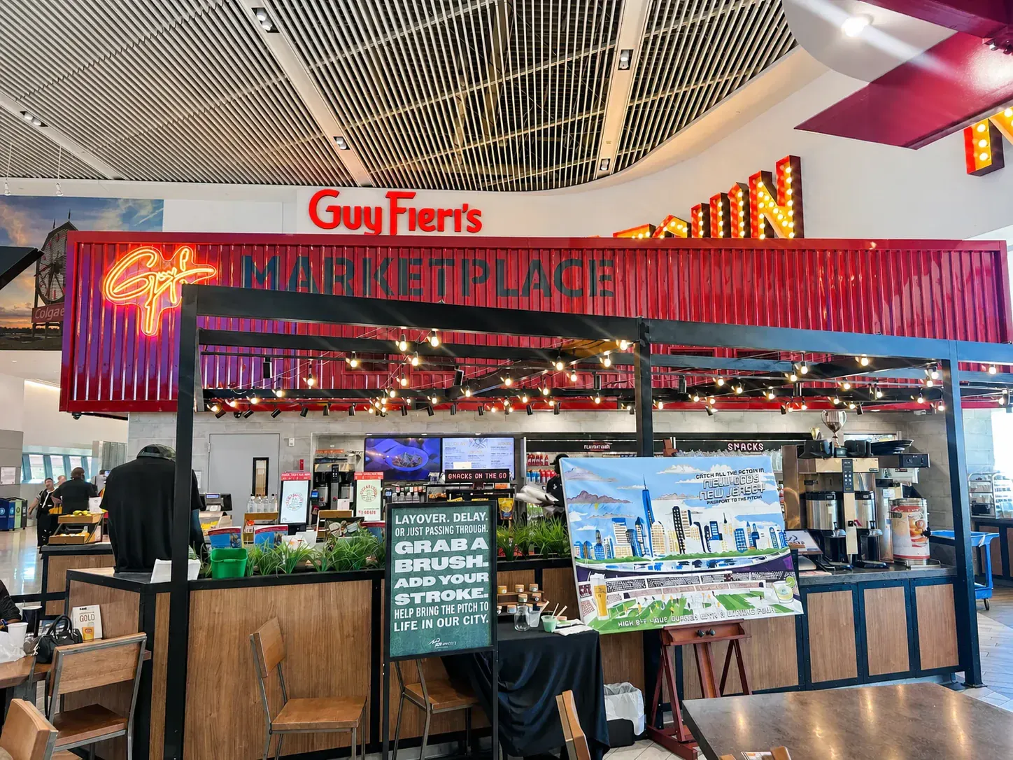 New York New Jersey World Cup paint-by-number mural displayed beneath the Guy Fieri's restaurant sign at Newark airport