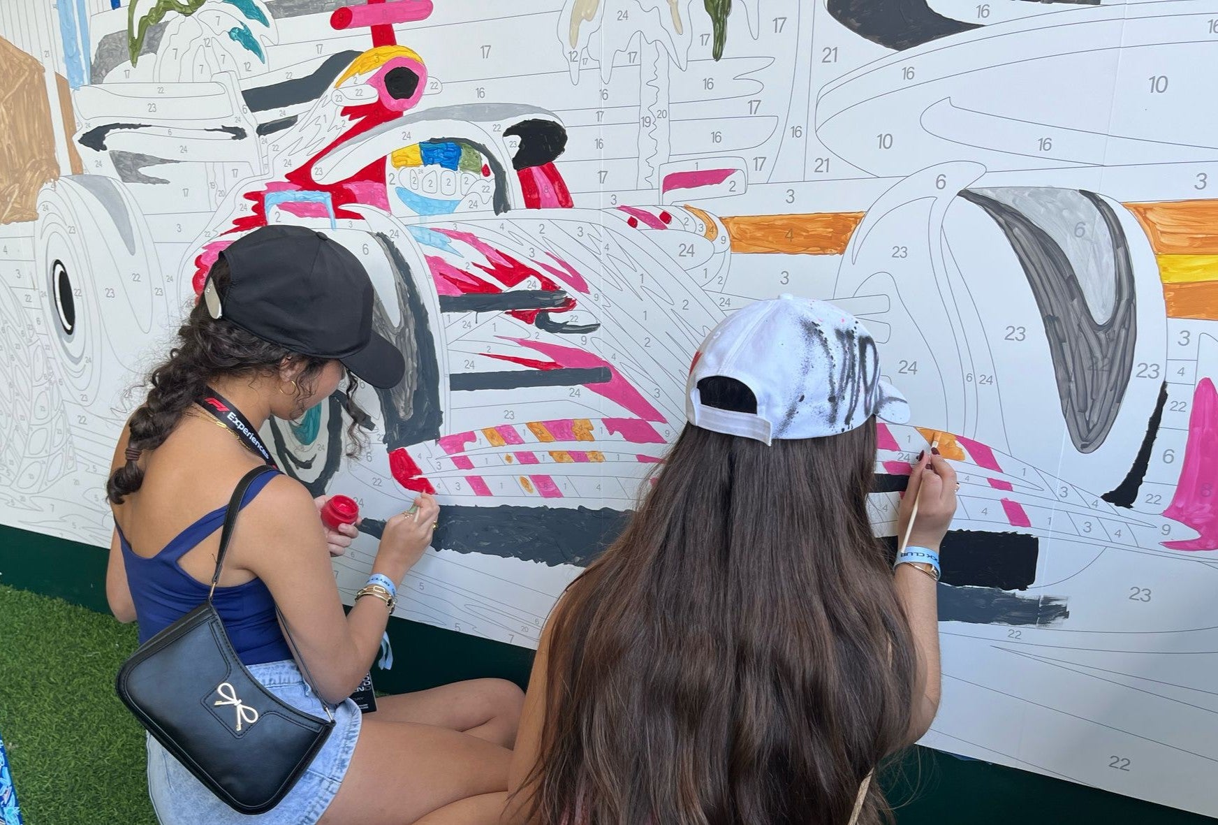 Large-scale paint by number mural being painted at a NASCAR racing event